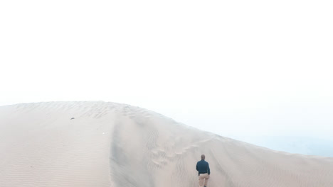 a-man-climbing-a-dune