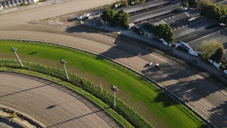 Aerial-tilt-up-shot-of-tractor-preparing-race-course-for-horse-event-in-summer-in-Buenos-Aires