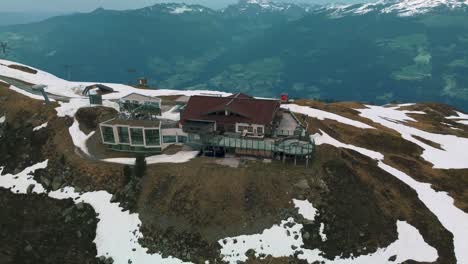 Wide-panorama-circular-flight-around-scenic-Zillertal-skiing-hiking-sports-Kristallhütte-Bergstation-cabin-near-Innsbruck-towards-the-snowy-glacier-mountain-tops-in-the-alps-on-a-cloudy-and-sunny-day