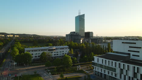 Sunrise-over-Gdansk-neighborhood-University-of-Gdansk-and-Oliva-Business-Center,-slowly-dolly-aerial-flight,-Poland