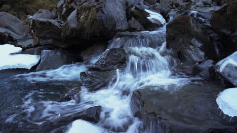 Agua-Que-Fluye-Por-Las-Rocas-Con-Hielo-En-Invierno---Cascada-Grundarfoss-Corriendo-Hacia-El-Río-En-Islandia
