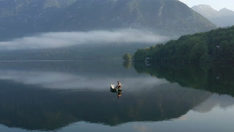 Lokaler-Fischer-Auf-Einem-Boot,-Das-In-Ruhigen-Gewässern-Des-Bohinj-Sees-In-Slowenien-Schwimmt