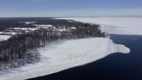 Aerial-shot-over-a-river-in-winter-on-a-sunny-day
