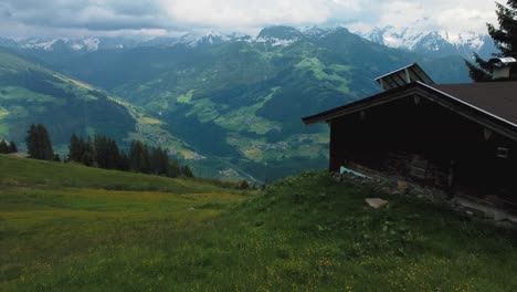 Aerial-drone-along-a-cottage-lodge-and-trees-in-nature-at-scenic-Zillertal-skiing-sport-hiking-and-trekking-vacation-mountain-valley-in-the-Austrian-Bavarian-alps-on-a-sunny-lush-summer-day