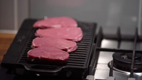 Adding-Raw-Steaks-To-An-Iron-Griddle