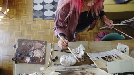 Artista-Lugar-Feliz-Trabajando-En-El-Estudio-De-Pintura-De-Pelo-Rosa