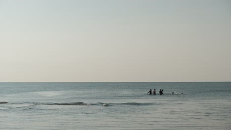 Silhouette-Der-Jungen-Männer-Der-Gruppe,-Die-Wasservolleyball-Im-Meer-Spielen