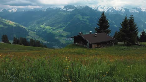 Aerial-drone-along-a-cottage-lodge-cabin-and-trees-in-nature-at-scenic-Zillertal-skiing-sport-hiking-and-trekking-vacation-mountain-valley-in-the-Austrian-Bavarian-alps-on-a-sunny-lush-summer-day