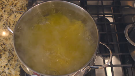 Overhead-view-of-pasta-in-a-pot-of-boiling-water-on-a-stove-top-in-a-kitchen