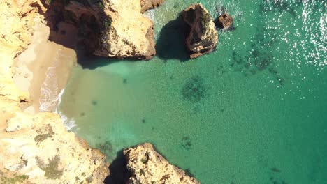 Idyllic-clear-Emerald-green-mediterranean-sea-on-Lagos-coast,-Algarve---Aerial-top-view