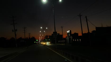 POV-shot-of-highway-road-at-dusk,-traffic-car-lights-illuminating-streets