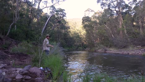 A-man-casts-a-lure-with-a-fishing-rod-into-a-beautiful-secluded-high-country-river-in-Australia