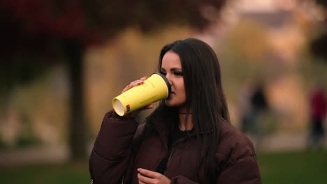 An-Attractive-Lady-Is-Drinking-Coffee-While-On-Iulius-Park,-Cluj-Napoca-In-Romania