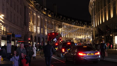 People-Shopping-at-Regent-Street-London-during-the-Christmas-Holiday-Season,-Nighttime