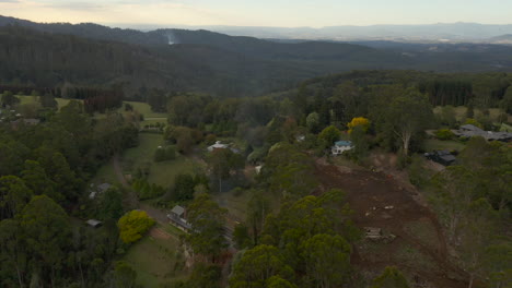 Smooth-aerial-accent-over-homestead-where-small-controlled-fires-can-be-seen-burning-in-the-distance