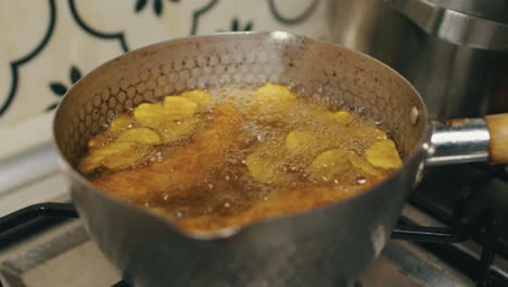 Potato-chips-and-chicken-legs-cooked-in-hot-boiling-oil-in-deep-cooking-pan