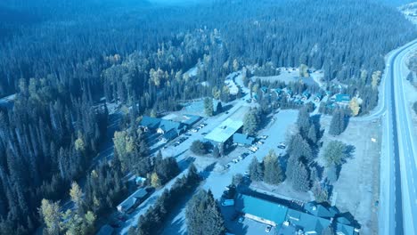 Manning-Park-aerial-birds-top-view-flyover-overlooking-presort-hotel,-indoor-swimming-pool,-outdoor-tennis-courts,-rows-of-chalets-sectioned-off-by-trees-at-mountain-valley-greens-changing-color-3-3