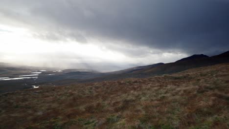 Ein-Schwenk-Zeigt-Langsam-Eine-Helle,-Windige-Landschaft-Mit-Bergen-Und-Lochs-Im-Nordwestlichen-Hochland-Von-Schottland,-Während-Lichtstrahlen-Den-Himmel-In-Der-Ferne-Durchdringen