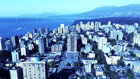 Downtown-Vancouver-aerial-flyover-Westend-giant-rainbow-flag-on-hotel-rooftop-overlooking-lgbtq-community-Stanley-park-mountains-shipping-freighters-on-horizon-recreational-speed-boats-enjoy-the-day