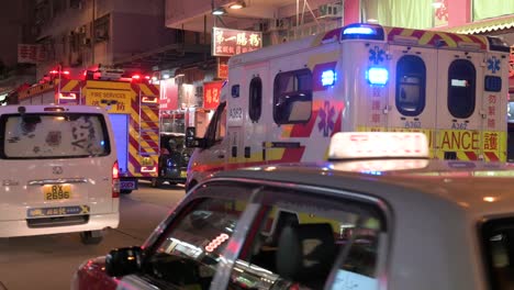 Ein-Krankenwagen-Und-Ein-Feuerwehrauto-Sind-Auf-Der-Straße-Stationiert,-Während-Ein-Ersthelfer-team-Der-Notfalleinheit,-Darunter-Feuerwehrleute-Und-Ein-Medizinisches-Team,-Auf-Einen-Notruf-In-Hongkong-Reagiert