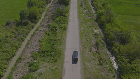 Slow-aerial-tracking-shot-of-a-black-SUV-heading-toward-a-power-plant