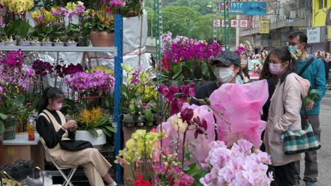 Chinesische-Käufer-Kaufen-Dekorative-Chinesische-Neujahrsblumen-Und-Pflanzen-An-Einem-Blumenmarkt-straßenstand-Vor-Den-Chinesischen-Neujahrsfestlichkeiten-Nach-Dem-Mond
