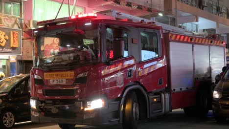 A-firetruck-and-first-responder-emergency-unit-team,-firefighters,-respond-to-a-distress-call-in-Hong-Kong