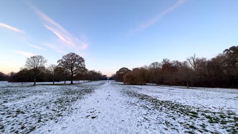 Wide-angle-shot-panning-left-across-field-and-park-covered-in-snow