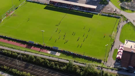 Tiro-De-Drone-Que-Muestra-Un-Partido-De-Fútbol-En-Una-Arena-En-La-Ciudad-De-Kuchl
