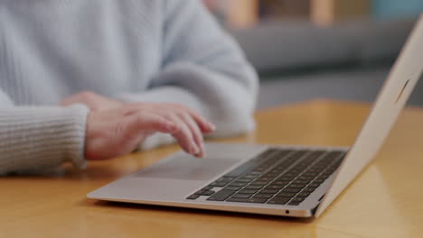Hands-of-unrecognizable-caucasian-woman-using-laptop,-close-side-view