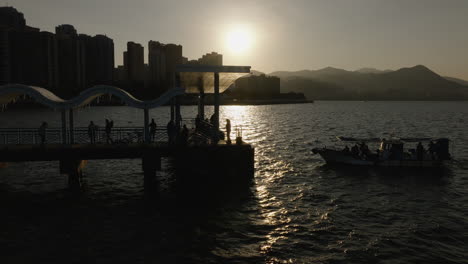 Luftschattenbildansicht-Des-Bootes-Am-Pier-In-Der-Stadt-Hongkong-Mit-Skyline-Der-Chinesischen-Metropole-Im-Hintergrund