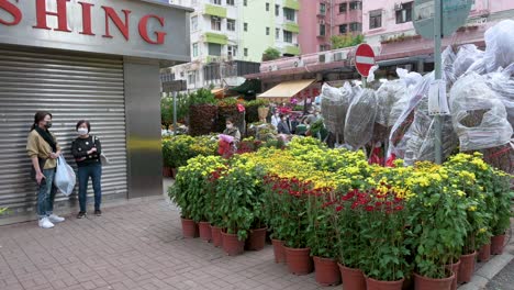 Peatones-Y-Compradores-Pasan-Por-Un-Puesto-Callejero-Que-Vende-Flores-Y-Plantas-Decorativas-En-Preparación-Para-El-Próximo-Año-Nuevo-Chino-Lunar-En-Un-Mercado-De-Flores-En-Hong-Kong
