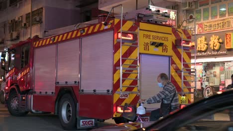 Ein-Feuerwehrauto-Ist-Auf-Der-Straße-Stationiert,-Während-Fahrzeuge-Durchfahren,-Während-Ein-Notfallteam,-Feuerwehrleute,-Auf-Einen-Notruf-In-Hongkong-Reagieren