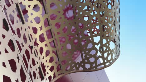 Modern-Building-is-a-luxury-shopping-mall-has-contemporary-art-design-brand-new-architectural-creative-idea-design-like-a-gift-box-shape-with-red-color-golden-ribbon-Islamic-pattern-and-the-sky-in-day