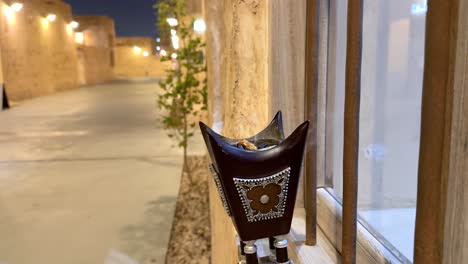 Arabian-Bakhoor-incense-burner-censer-with-smoke-and-blurred-background-of-old-city-down-town-in-Doha-Qatar-Al-Wakrah-Souq-with-gold-luxurious-lighting-renovation-houses-to-visit-at-night-walk-family