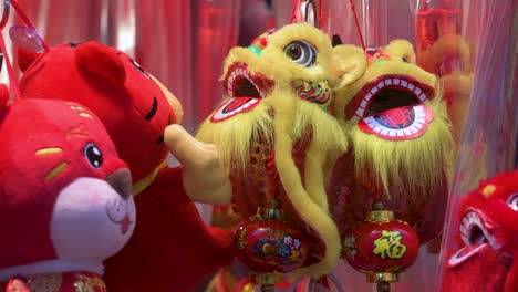 Chinese-New-Year-decorative-ornaments,-such-as-yellow-lions,-seen-for-sale-at-a-shop-ahead-of-the-Lunar-Chinese-New-Year-in-Hong-Kong