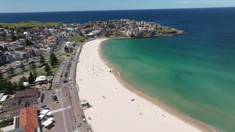 Bondi-Beach-With-Tourists-During-Daytime-In-Sydney,-New-South-Wales,-Australia---aerial-drone-shot