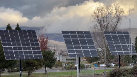 A-row-of-solar-panels-with-massive-clouds-in-the-background