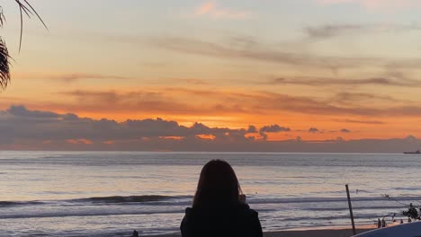 Zeitlupe-Von-Menschen-Am-Strand-Von-Carcavelos,-Langsam-Bilden-Sich-Wellen-Und-Brechen,-Schöner-Atlantik,-Tiefgelber-Sonnenuntergang-Auf-Wasserspiegelungen,-Portugal