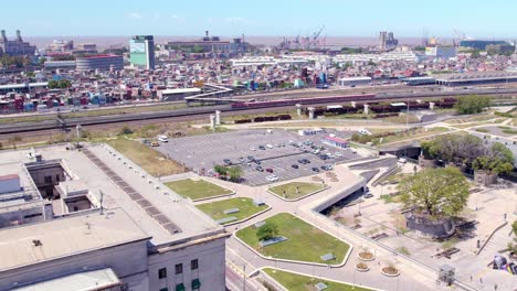 Aerial-view-of-the-contrast-of-an-empty-parking-lot,-the-train-as-sustainable-transport-and-one-of-the-most-dangerous-and-decadent-neighborhoods-in-Buenos-Aires