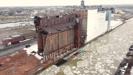 Large-abandoned-factory-next-to-frozen-river