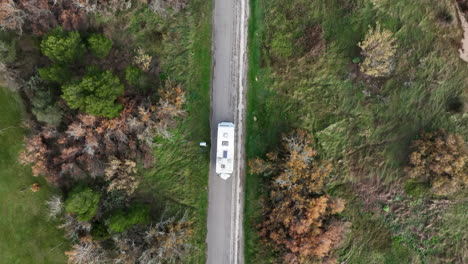 Motor-home-camper-van-driving-scenic-rural-country-road,-Top-down-aerial-view