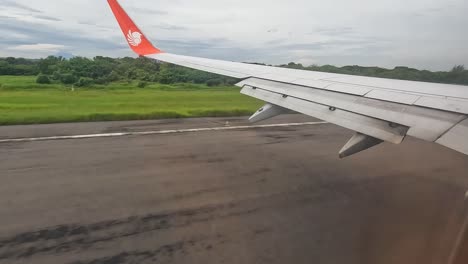 Plane-taking-off-from-asphalt-runway,-window-and-wing-view