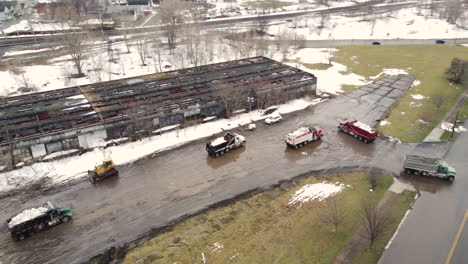 Aerial-view-revealing-snow-removal-trucks-cleaning-up-roads-after-December-2022-North-American-deadly-winter-storm,-Buffalo,-New-York,-USA