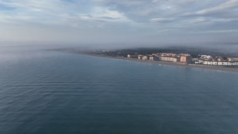Estartit-Coastal-village,-Costa-Brava,-Girona-shore-aerial-view-descending-across-blue-Mediterranean-ocean
