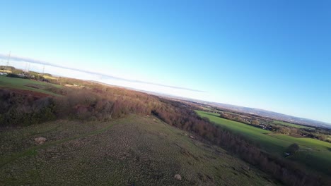 FPV-drone-flying-across-Billinge-hill-beacon-autumn-Lancashire-farmland-meadow-woods