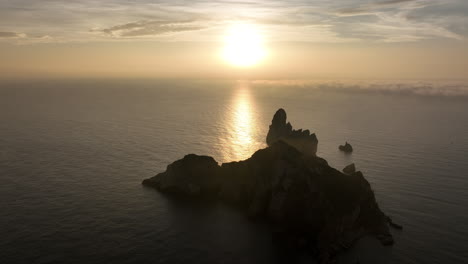 Aerial-view-orbiting-sunrise-behind-Medes-islands-breathtaking-golden-shimmering-Mediterranean-sea-horizon