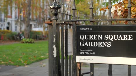 Queen-Square-Gardens-Welcome-Signage-Hanging-On-Steel-Fence-In-London,-United-Kingdom