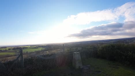 FPV-drone-flying-across-Billinge-hill-beacon-viewpoint-and-autumn-Lancashire-farmland-landscape