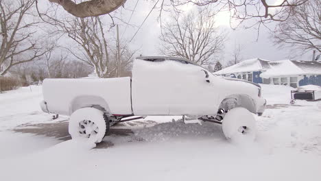 Snow-covered-pickup-truck-on-driveway-after-storm-in-Canada,-handheld